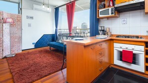 A compact kitchen with a microwave, stove, and a red towel hanging on the oven. - Best Location in Santiago, Chile! Great View & Full Equiped Apartment! (Santiago)