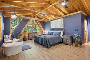 Una camera da letto con un letto grande, una vasca da bagno e una mappa appesa al muro.