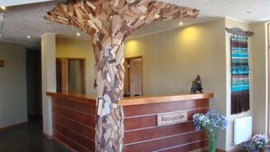 Un mostrador de recepción con una estructura de pilar geométrico de madera.