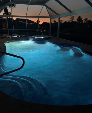 An indoor swimming pool with a clear view of the sunset outside. - SPACIOUS 4 BEDROOMED HOME (Rotonda West)