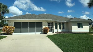 Einbungalow mit Garage, überdachter Auffahrt und gepflegtem Rasen.