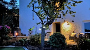 A well-maintained garden with a lawn, a tree, and a patio area with outdoor furniture. - Glasgow Emo (Glasgow)
