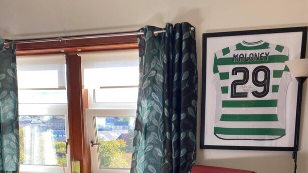 A room with a wooden desk, a red leather chair, a window with curtains, and a framed jersey on the wall. - Glasgow Emo (Glasgow)