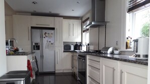 A modern kitchen with white cabinets, stainless steel appliances, and a granite countertop. - Glasgow Emo (Glasgow)