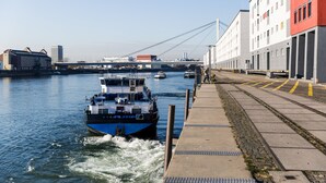 A river with a blue boat named "PILATOR" and a bridge in the background. - Holiday Inn Mannheim City - Hauptbahnhof by IHG (Mannheim)