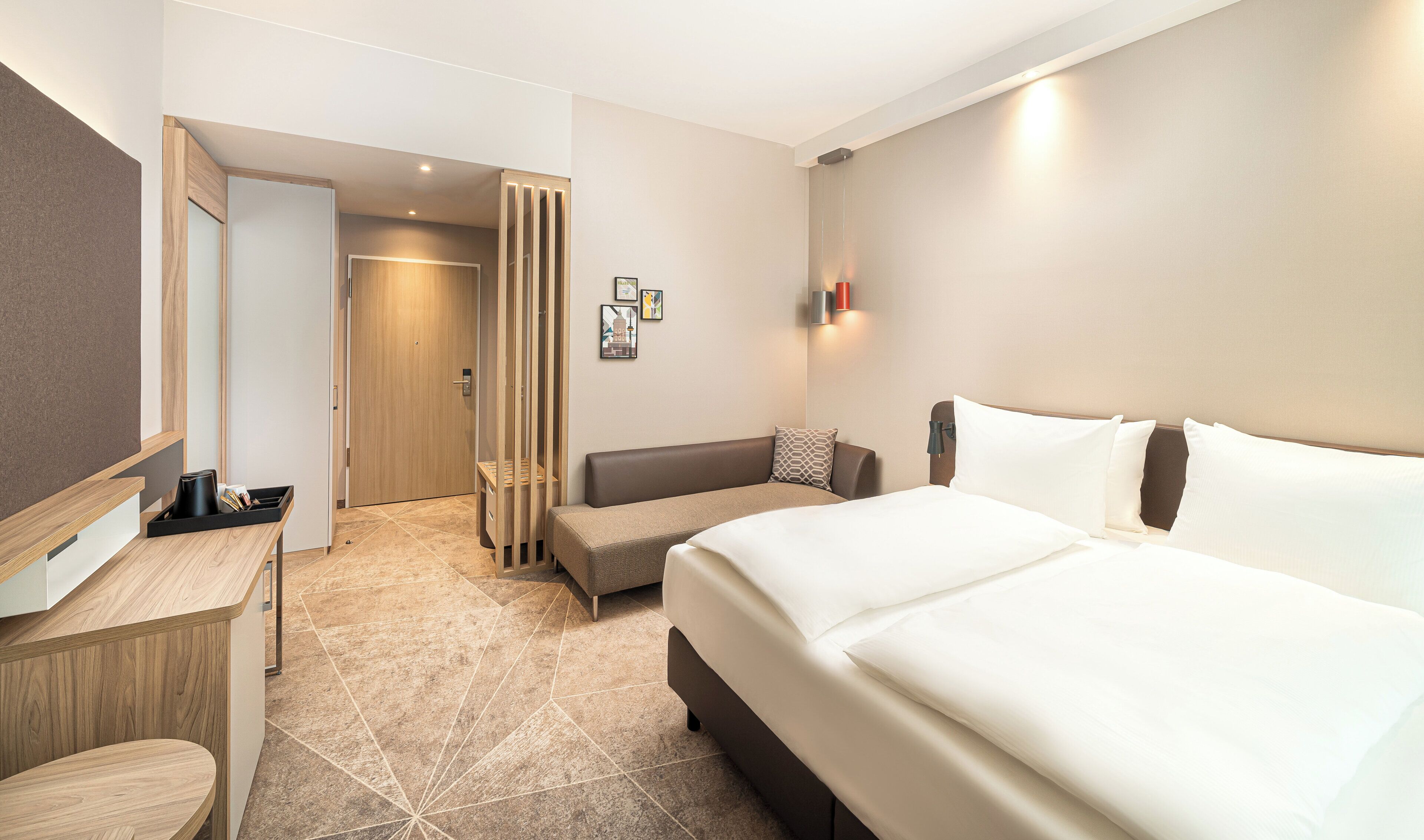 Ein Hotelzimmer mit Bett, Schreibtisch, Stuhl, Sofa und Bad.