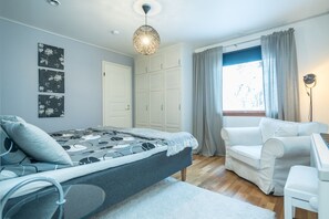 A bedroom with a bed, a desk, a chair, and a wardrobe.