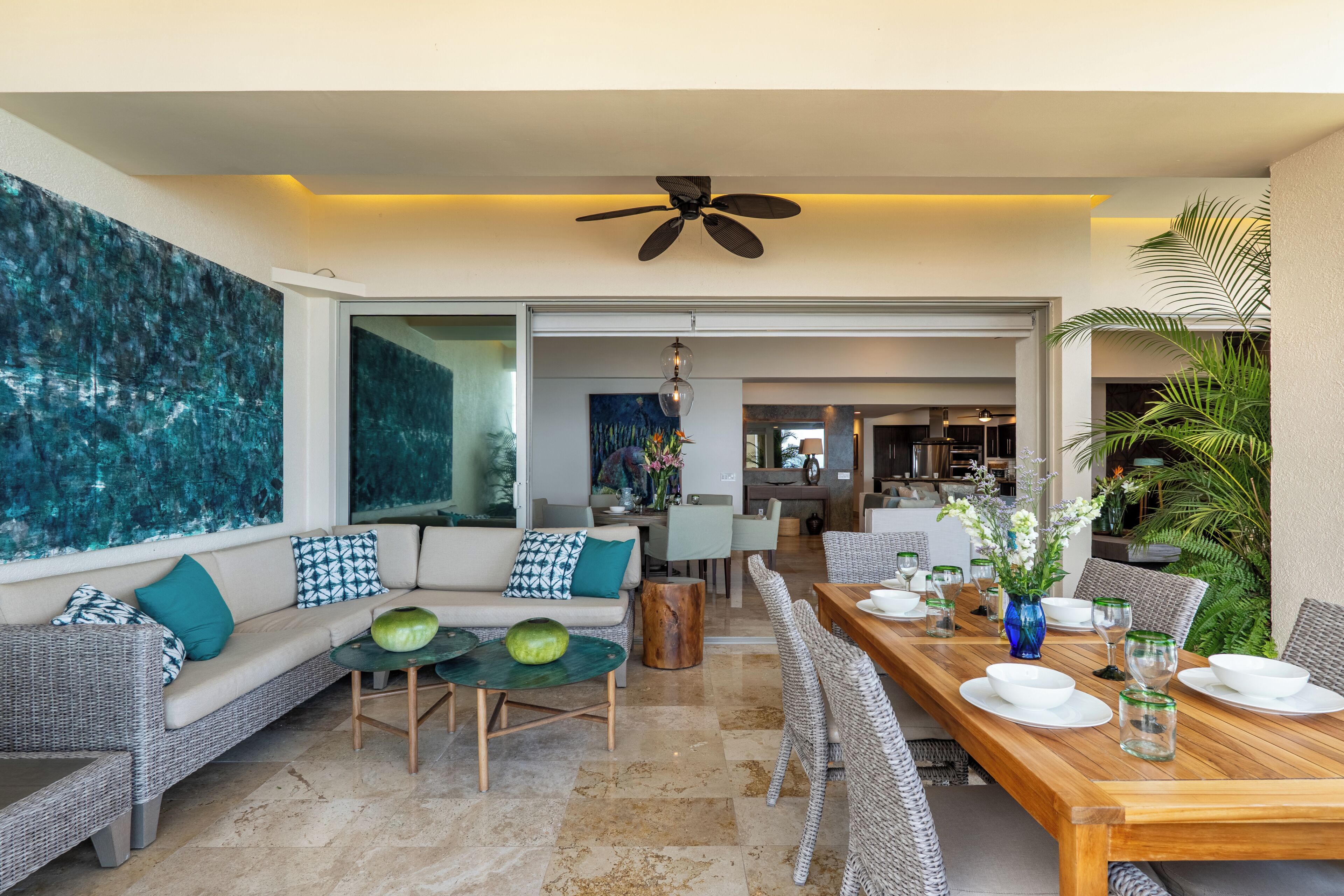 A modern living room with a sofa, dining table, and a ceiling fan.