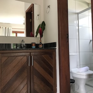 A bathroom with a wooden herringbone vanity, a mirror, a towel rack, and a toilet.