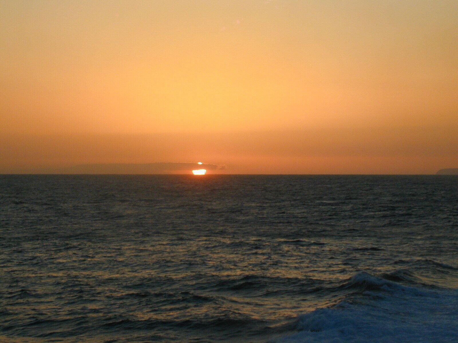 Un atardecer sobre un mar tranquilo.