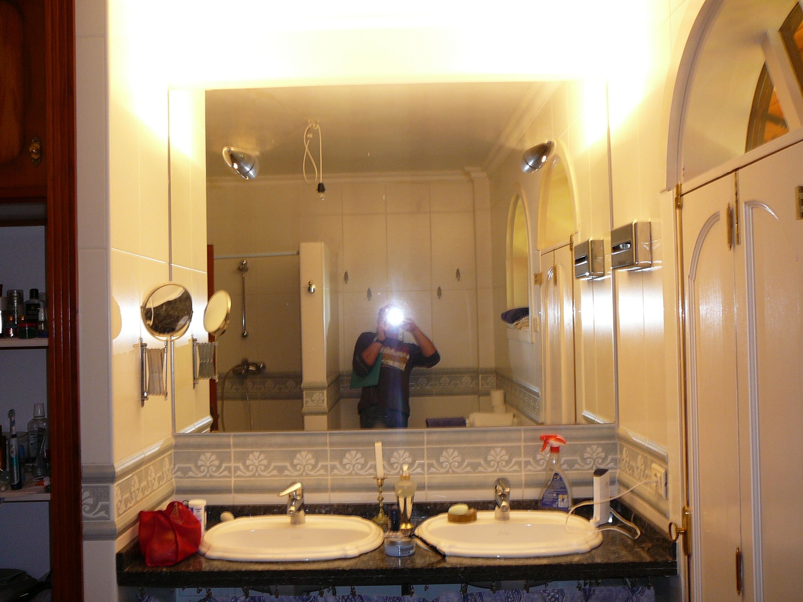 A bathroom with two sinks, a mirror, and a shower.
