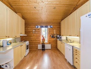 Cucina in stile baita di legno con pensili, un fornello, un forno a microonde e un lavello.