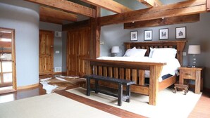 A bedroom with a wooden bed, a bench, and a rustic ceiling. - Luxury Ranch Compound on 300 acres, just outside Galena Territory. 30 bedrms. (Elizabeth)