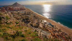Una località balneare con diversi edifici, una spiaggia e una montagna sullo sfondo.