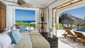 A bedroom with a large bed, a ceiling fan, and a view of the ocean. - 2 FREE NIGHTS IN CABO at Villa Buena Vida! (Cabo Corridor)