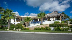A Mediterranean-style villa with a covered patio, palm trees, and a stone wall. - 2 FREE NIGHTS IN CABO at Villa Buena Vida! (Cabo Corridor)