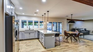 A modern kitchen with a central island, built-in appliances, and pendant lighting.