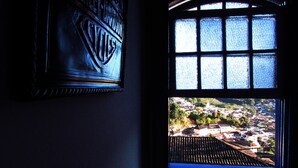 Une pièce avec une fenêtre donnant sur un beau paysage, un panneau décoratif au mur et un sol carrelé.
