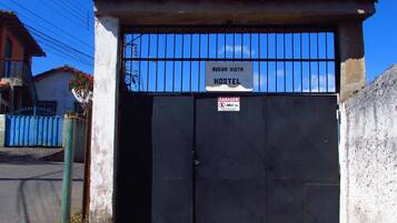 A hostel gate with a sign reading "BUENA VISTA HOSTEL" and a "GARAGEM" sign below it.
