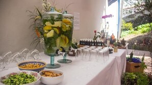 Une table avec un distributeur de boissons, des bols remplis de collations et une variété de verres.