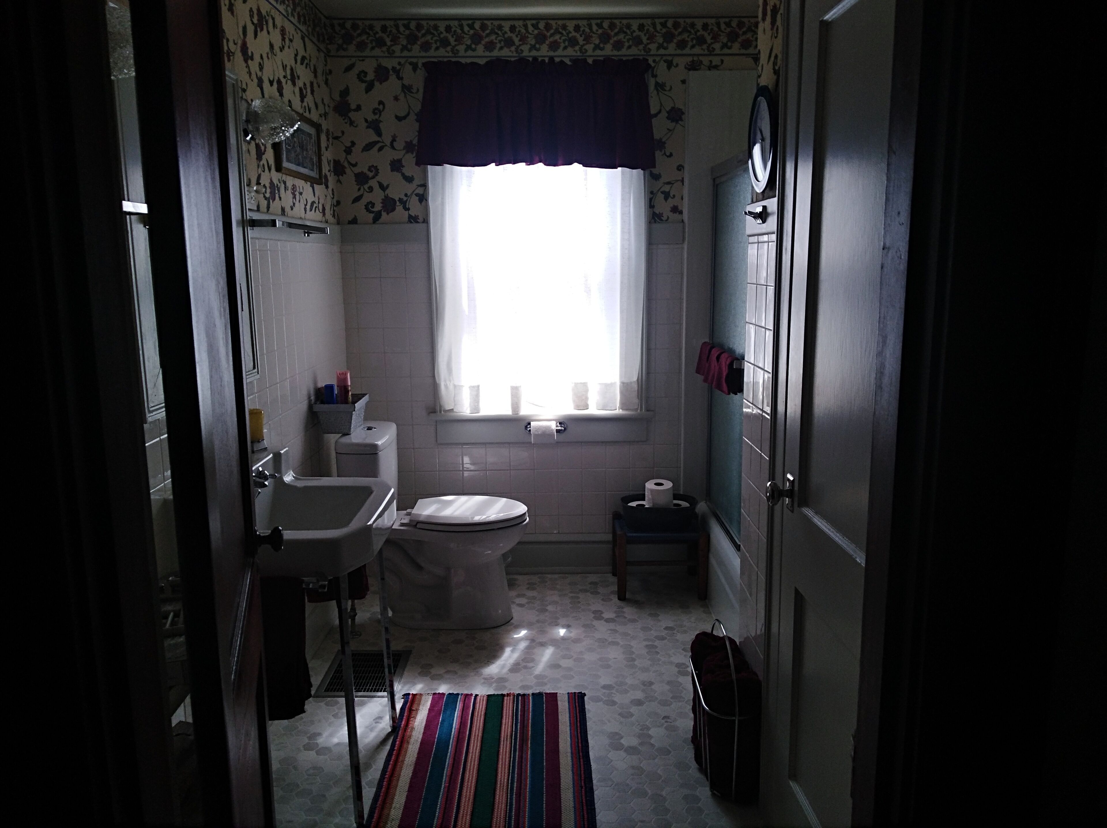 Un baño con inodoro, lavamanos y ventana.