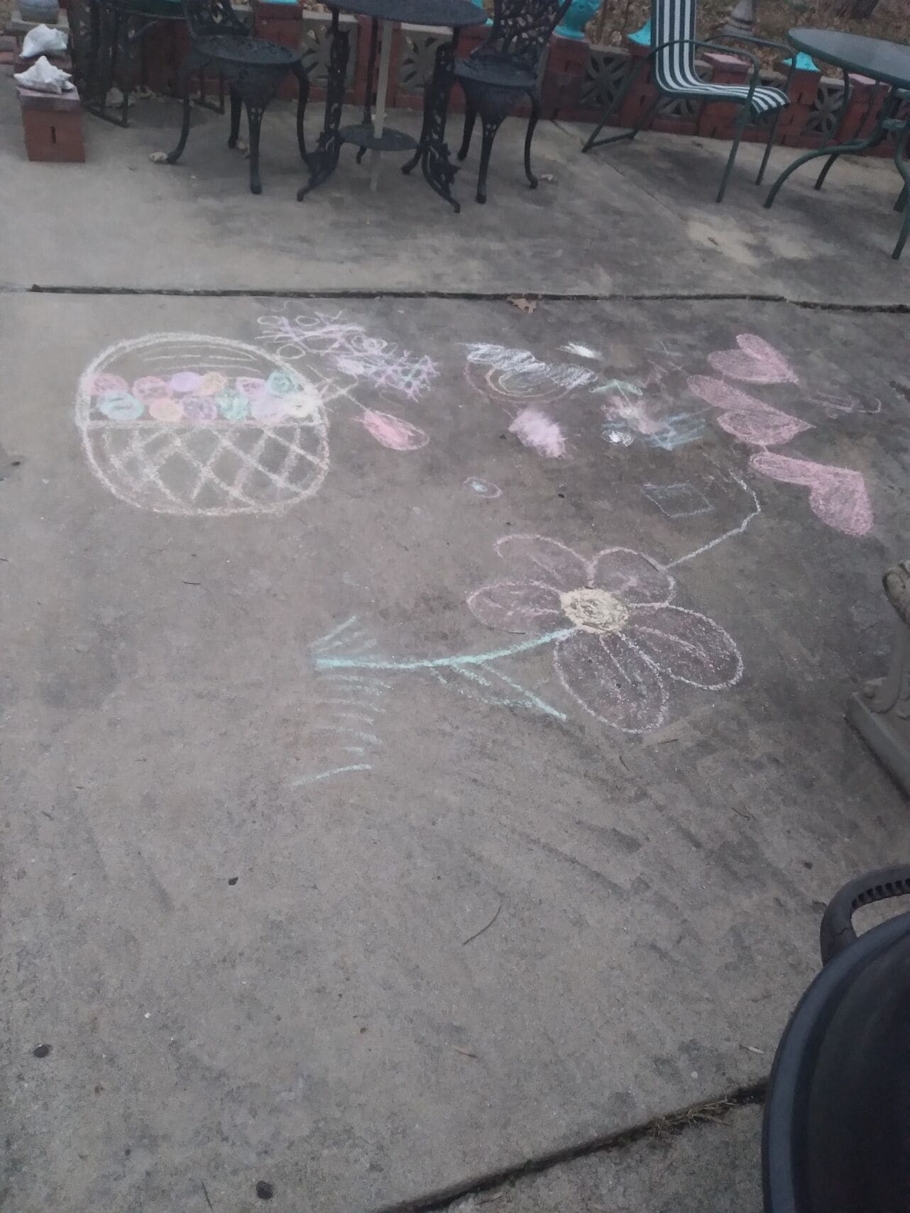 Une terrasse en béton avec des meubles d’extérieur et des dessins à la craie.