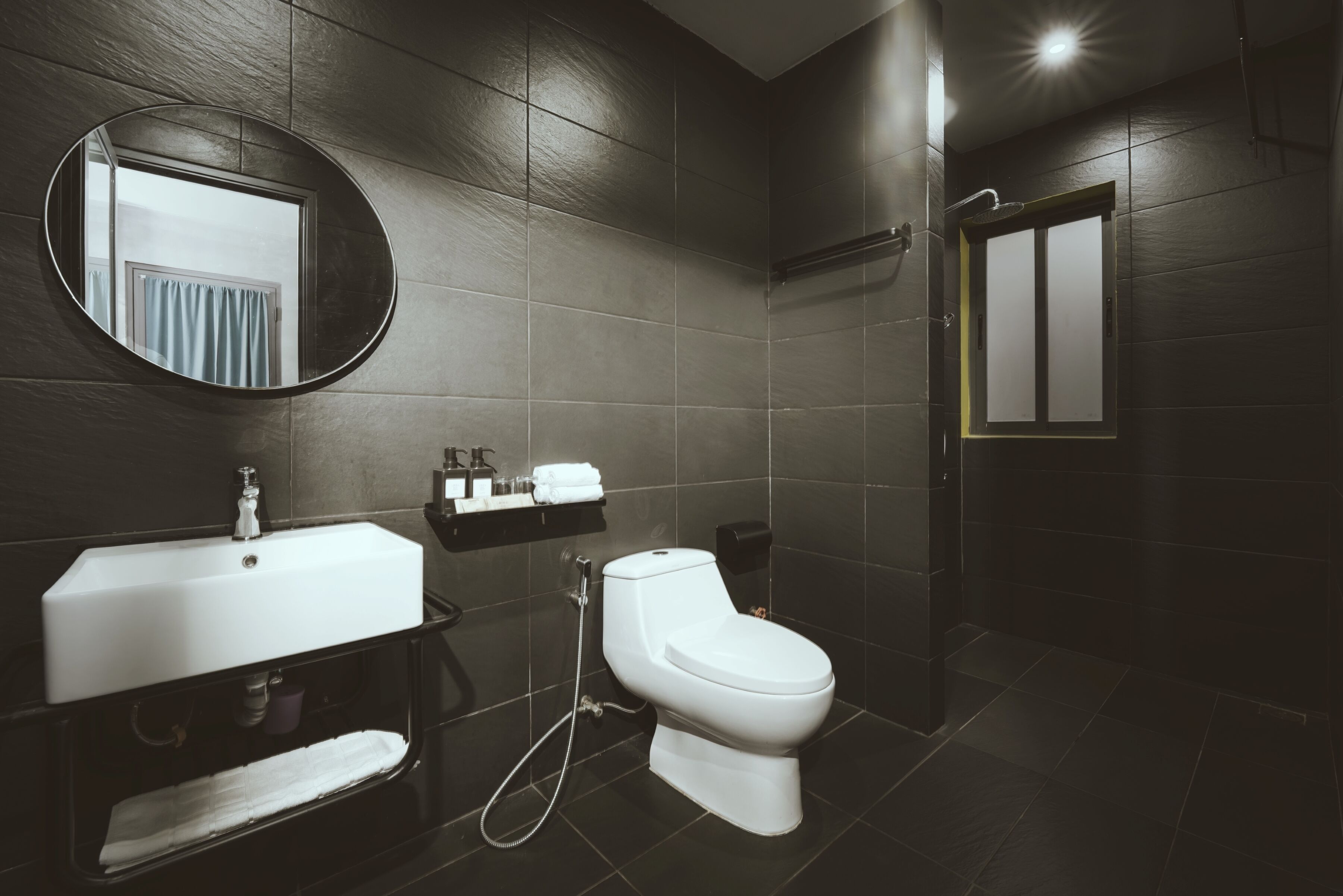 A modern bathroom with a white sink, toilet, and shower.