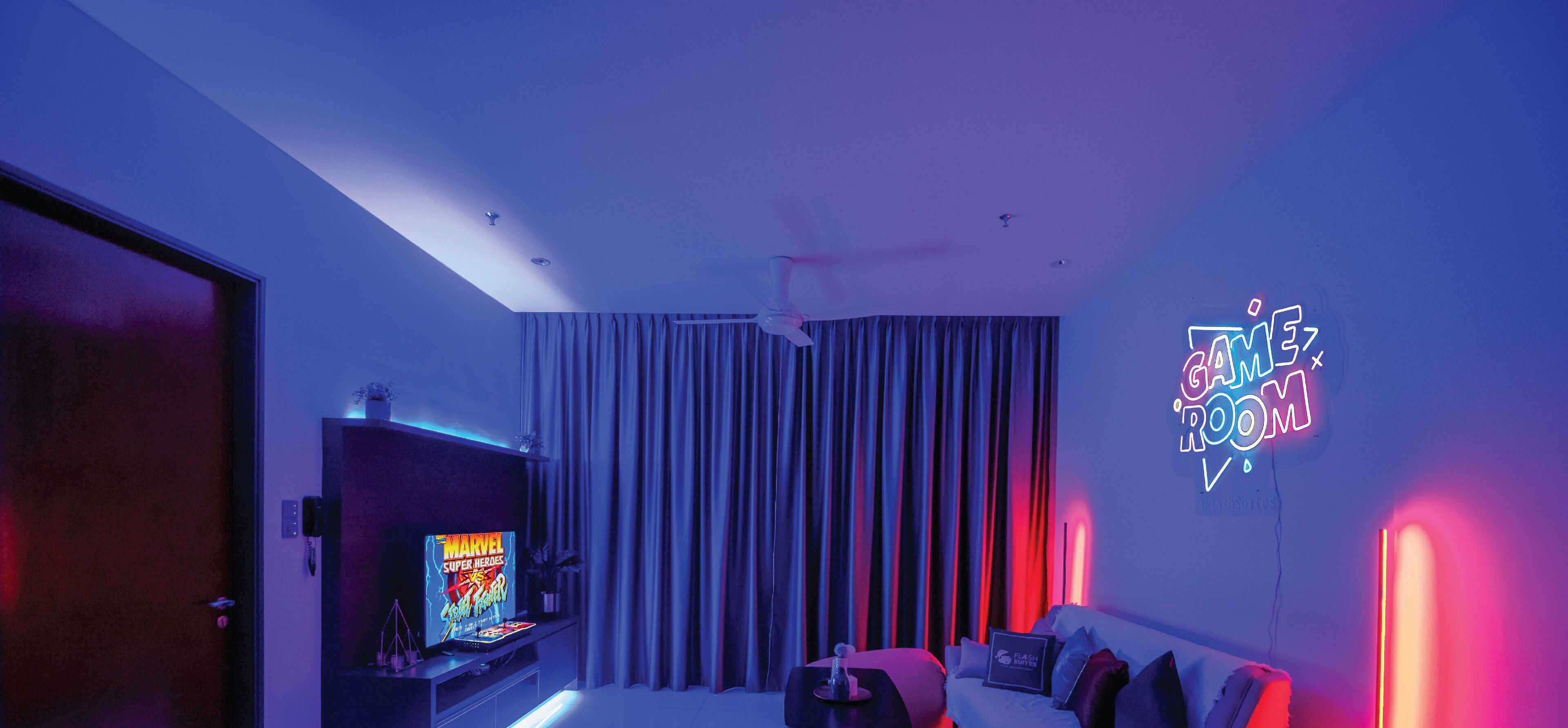 A modern living room with a flat-screen TV displaying 'Marvel Super Heroes.'