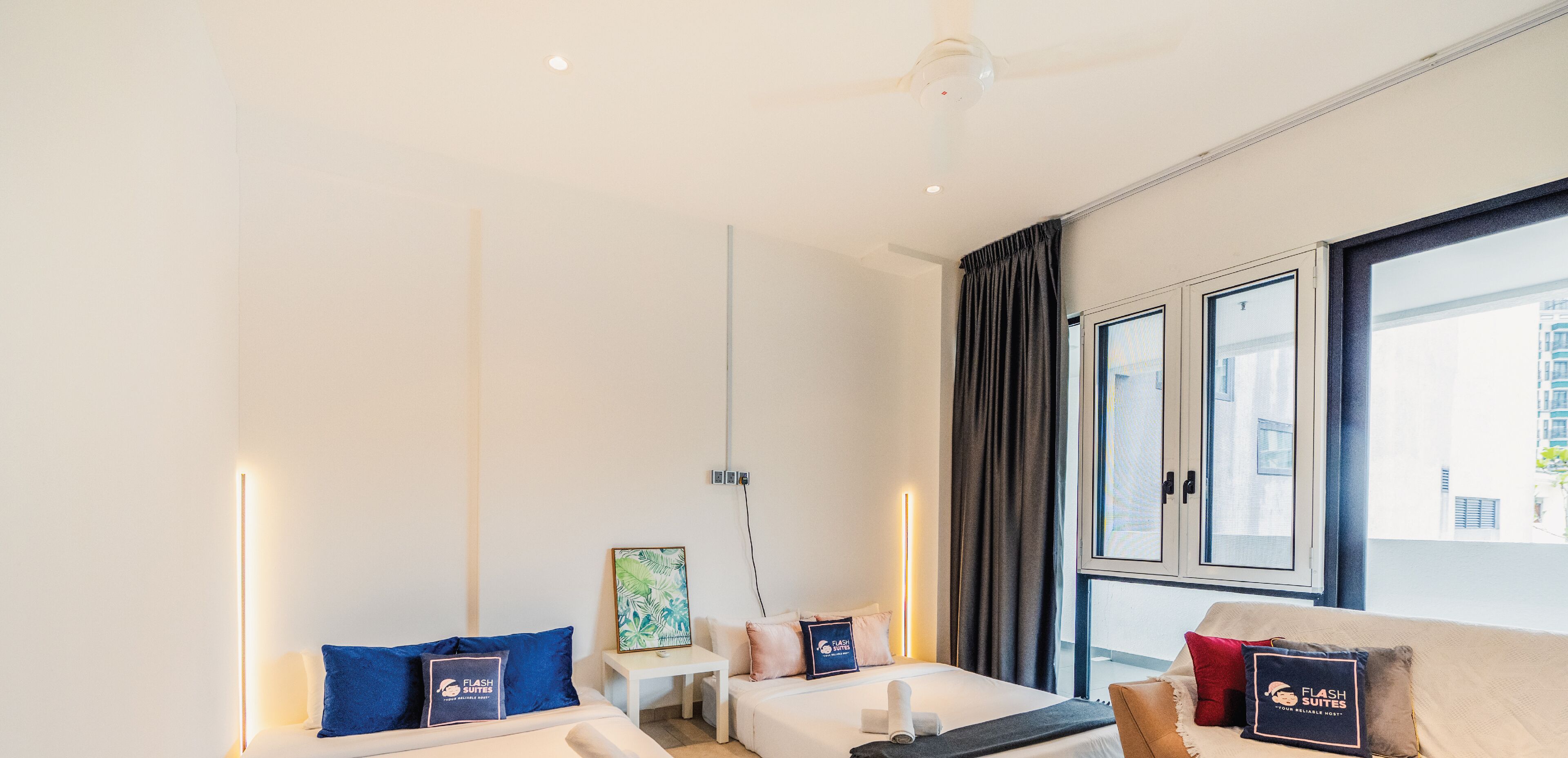Une chambre d’hôtel moderne, équipée d’un lit, d’un canapé, d’une petite table et d’une fenêtre avec des rideaux.