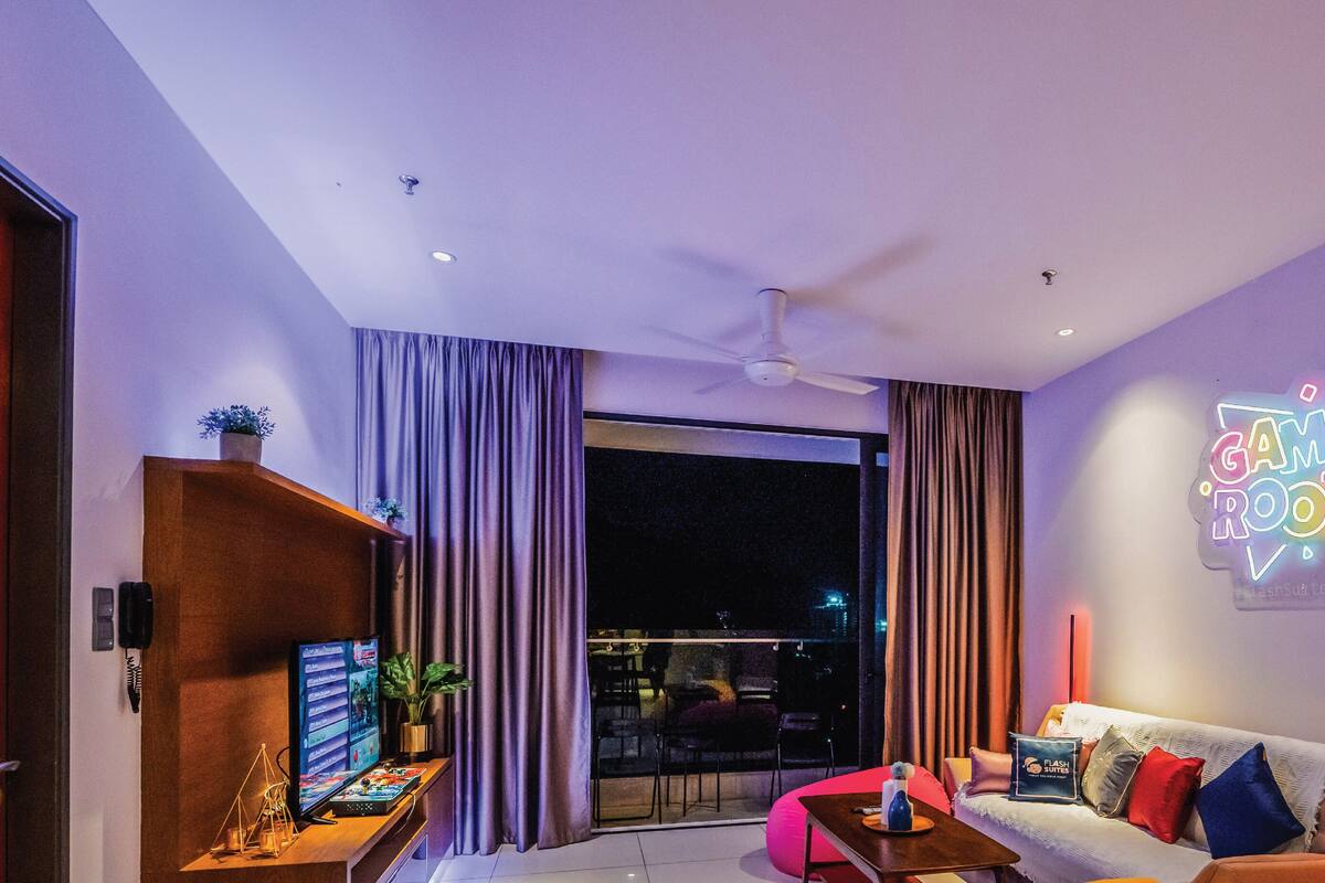 A modern living room with a sofa, a coffee table, and a neon sign.