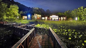 A lakeside hotel with glass facades, wooden deck, and surrounding greenery. - Haeyeorim Village (Yeoju)