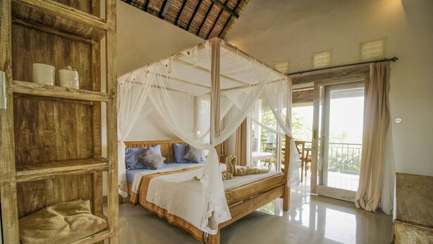 A four-poster bed with a canopy, wooden shelves, and a view of the outdoors. - Villa Di Sawah Pejeng (Ubud)