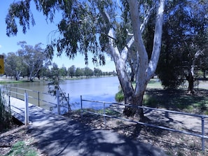 A park with a lake, trees, and a walking path.