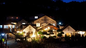 A multi-story building with illuminated signage reading "Pension". - Taean White Sand Pension (Taean)
