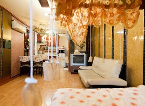 A hotel room with a bed, a sofa, a TV, and a dining area with a table and chairs. - Taean White Sand Pension (Taean)