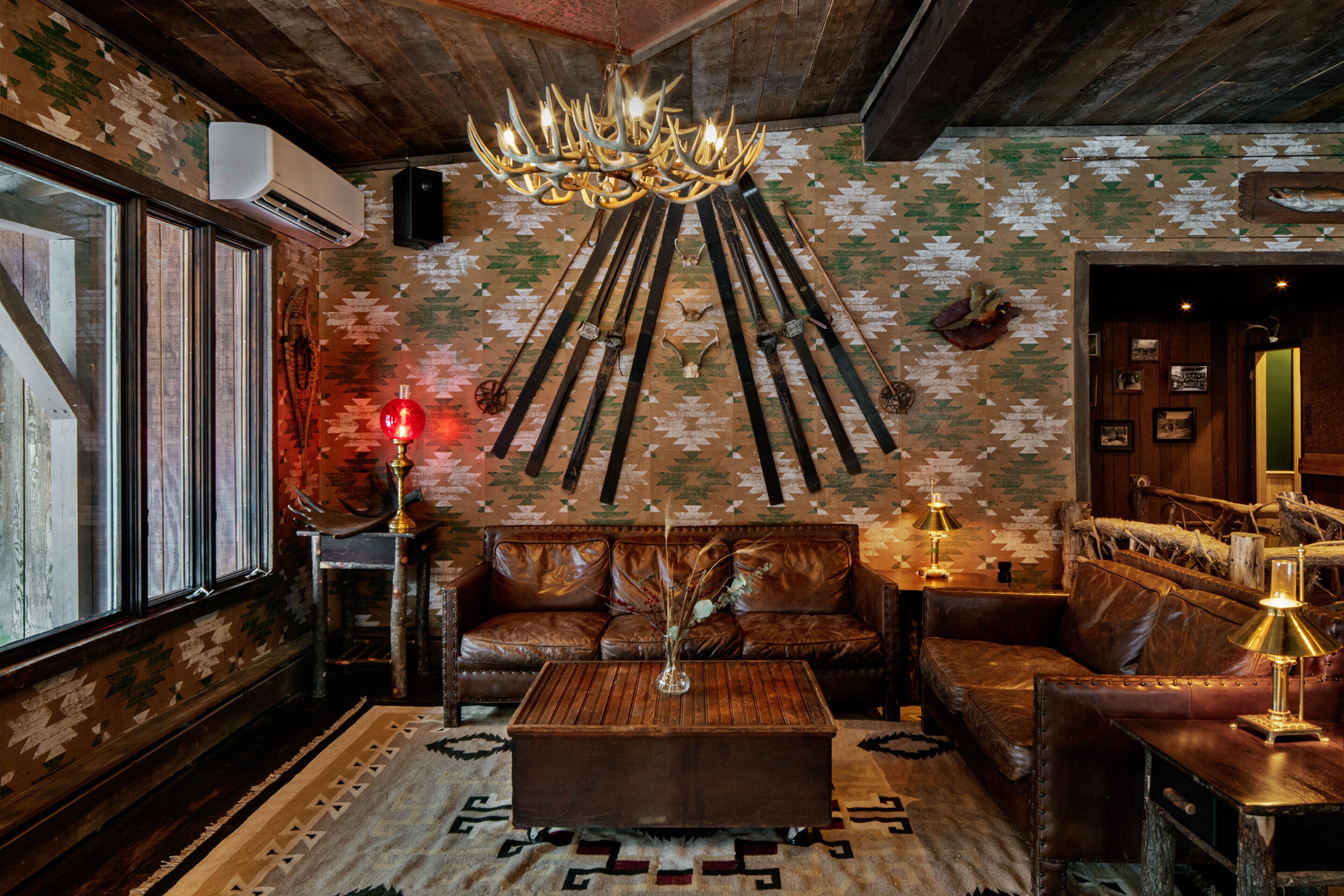 A cozy living room with a leather sofa, a wooden coffee table, and a patterned rug.