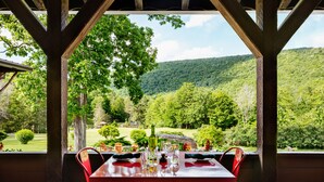 A table set for two with a view of a lush green landscape and hills in the background.