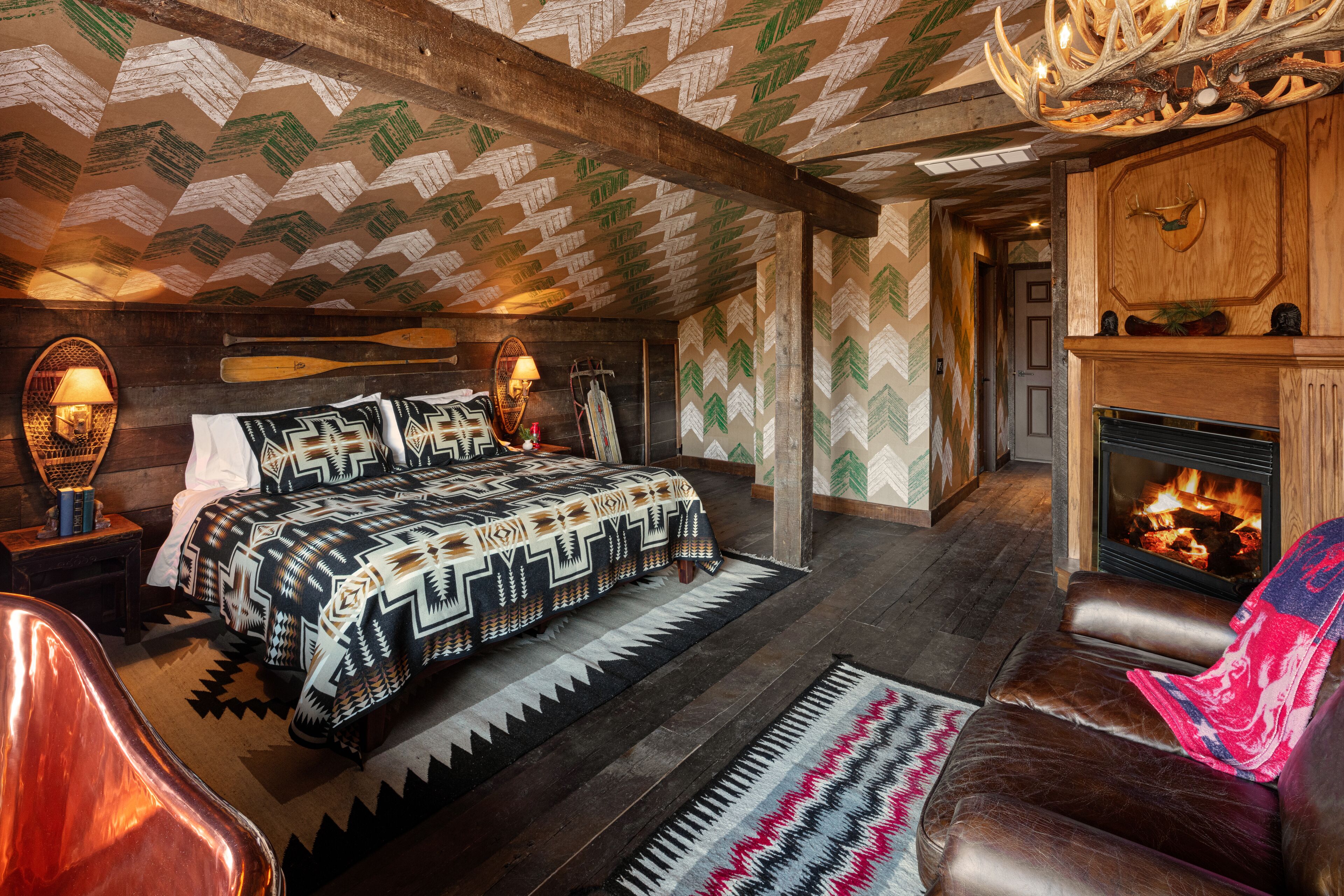 Una habitación acogedora con una cama, una chimenea y un sillón de cuero.