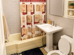 Bathtub, hair dryer, towels, shampoo