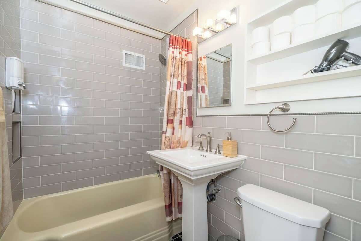 Bathtub, hair dryer, towels, shampoo