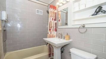 Bathtub, hair dryer, towels, shampoo