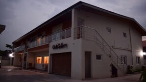 Un bâtiment à deux étages, doté d’un balcon à l’étage supérieur, d’un garage au rez-de-chaussée et d’une enseigne indiquant « OABGallery ».