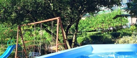 Una piscina al aire libre, sillones reclinables de piscina