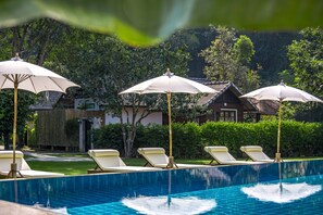 Una piscina al aire libre, tumbonas