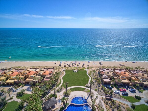 Um resort com piscina, praia e vista para o oceano.
