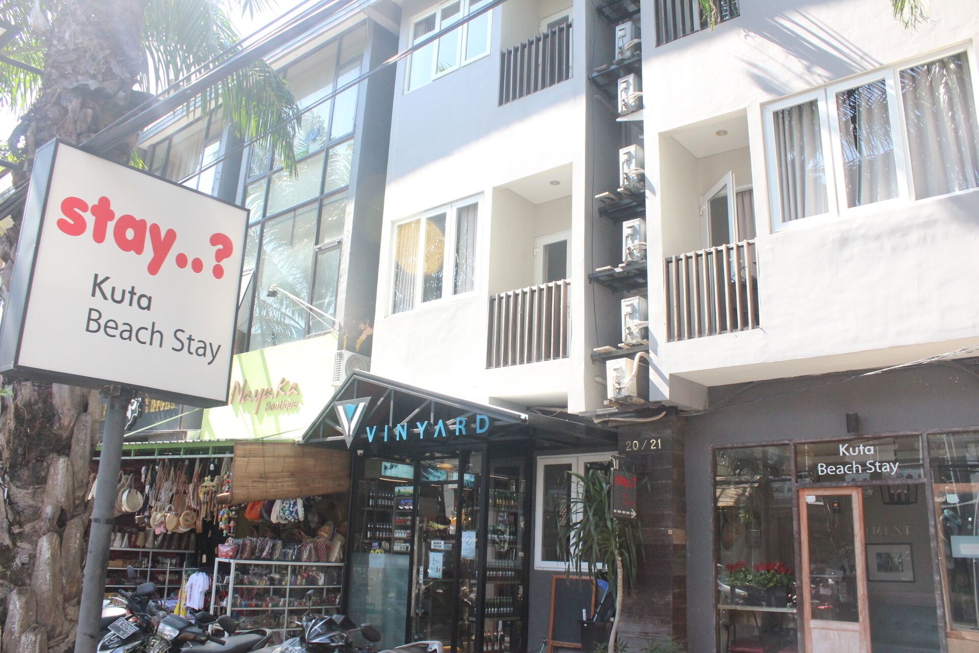 Un edificio de varios pisos con un letrero que dice Kuta Beach Stay.
