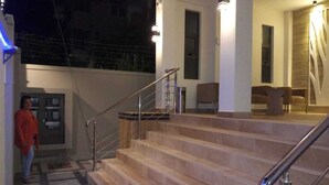 A staircase leading to a second-floor area with a railing, a door, and a window. - The Monalysa Suites & Residence (Grand-Baie)