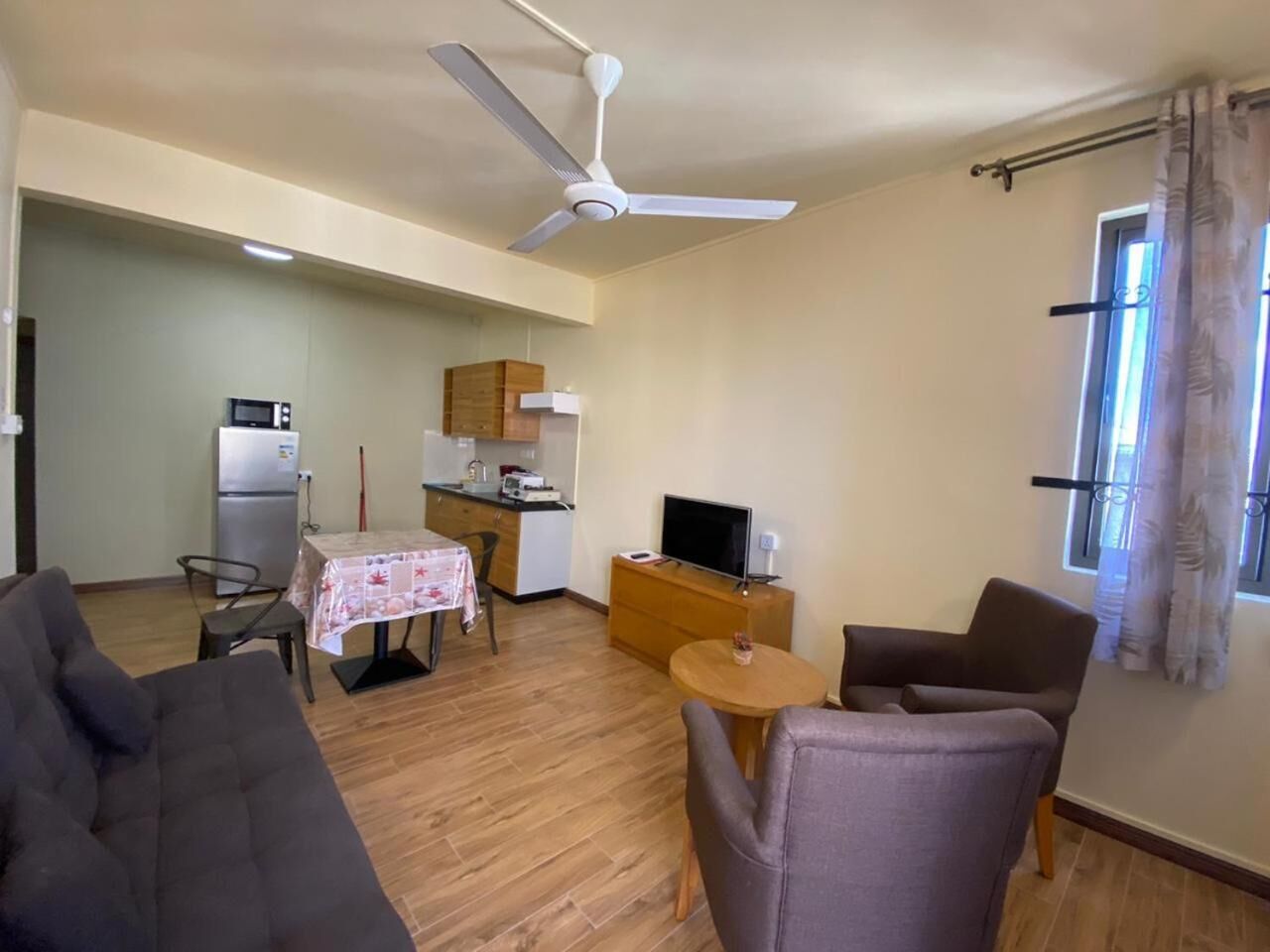 Un espace de vie compact comprenant un coin repas, une kitchenette et un espace détente.