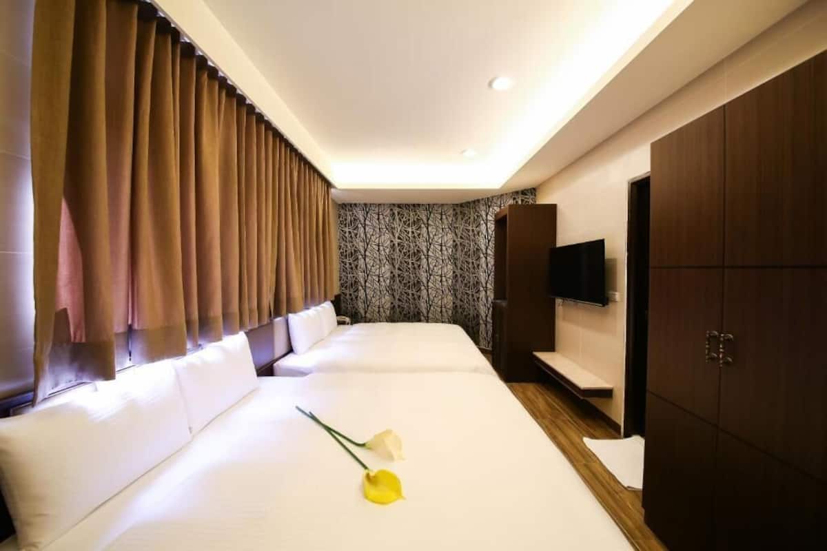 A hotel room with a large bed, a TV, and a wardrobe.