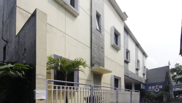 A multi-story building with a flat facade, large windows, and a gated entrance. - Ungu Residence Syariah (Bandung)